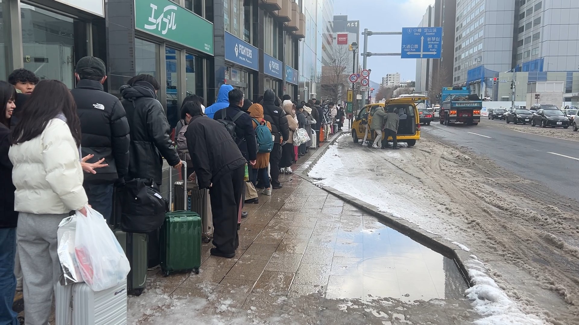 新千歳空港行きのバスを待つ人々