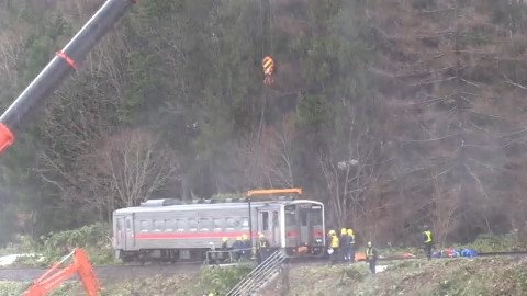 クレーンで釣りあげられる列車