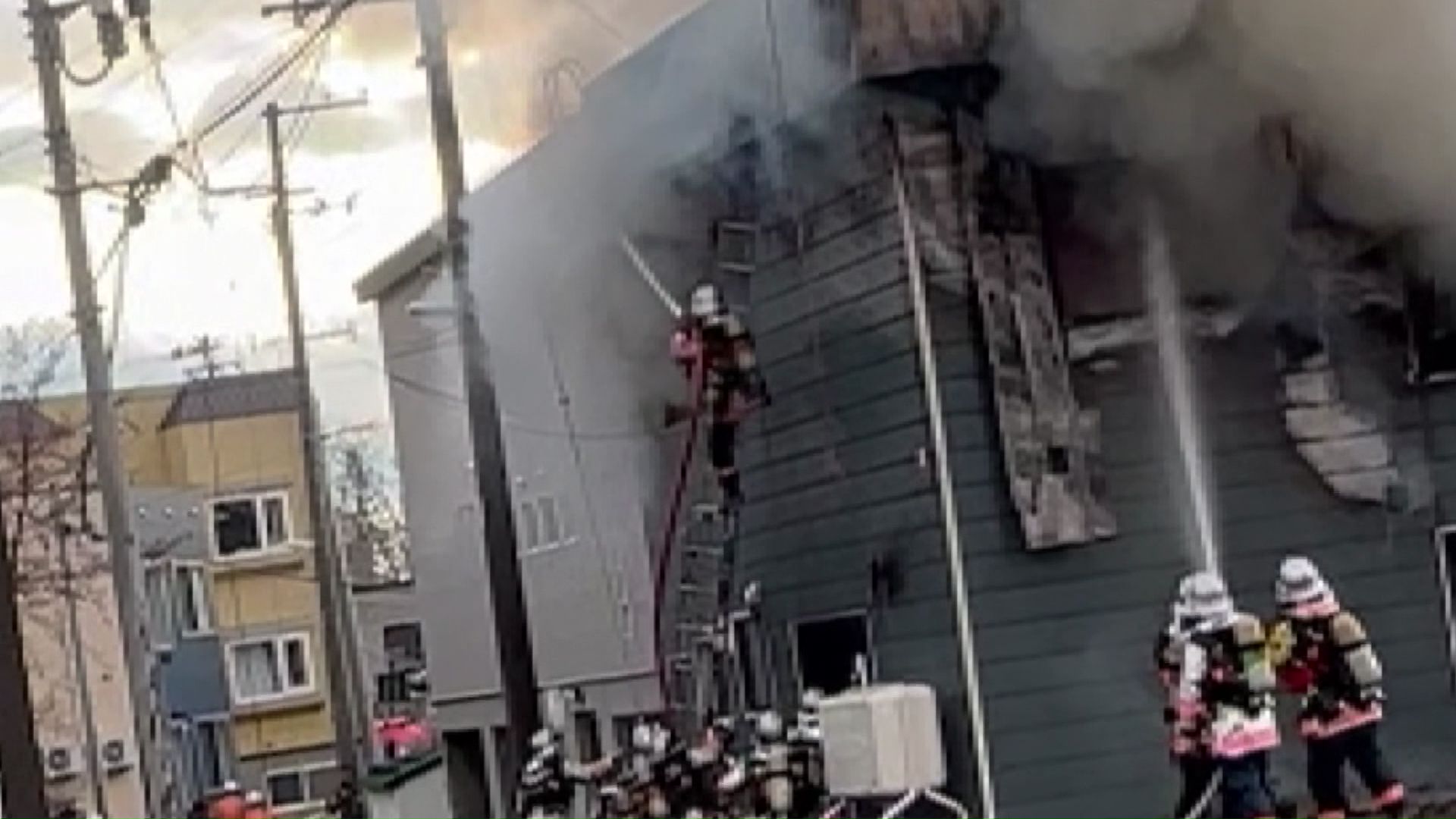 はしごを使い消火中の消防士