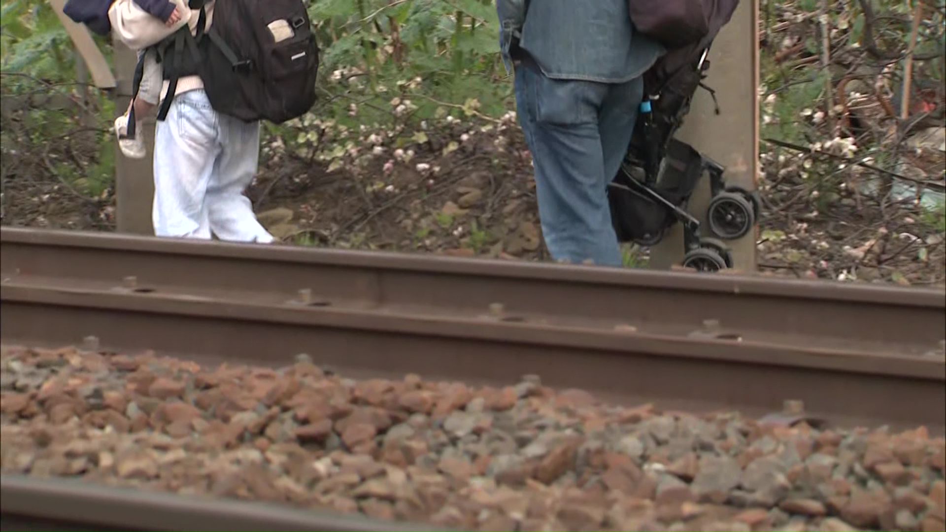 列車から線路に降りる普通列車の乗客
