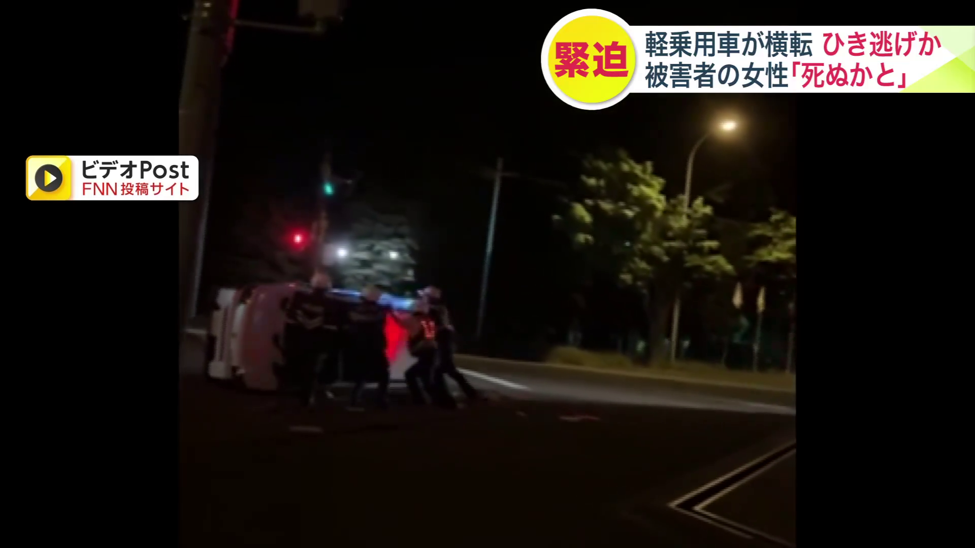 横転した車を押す警察官