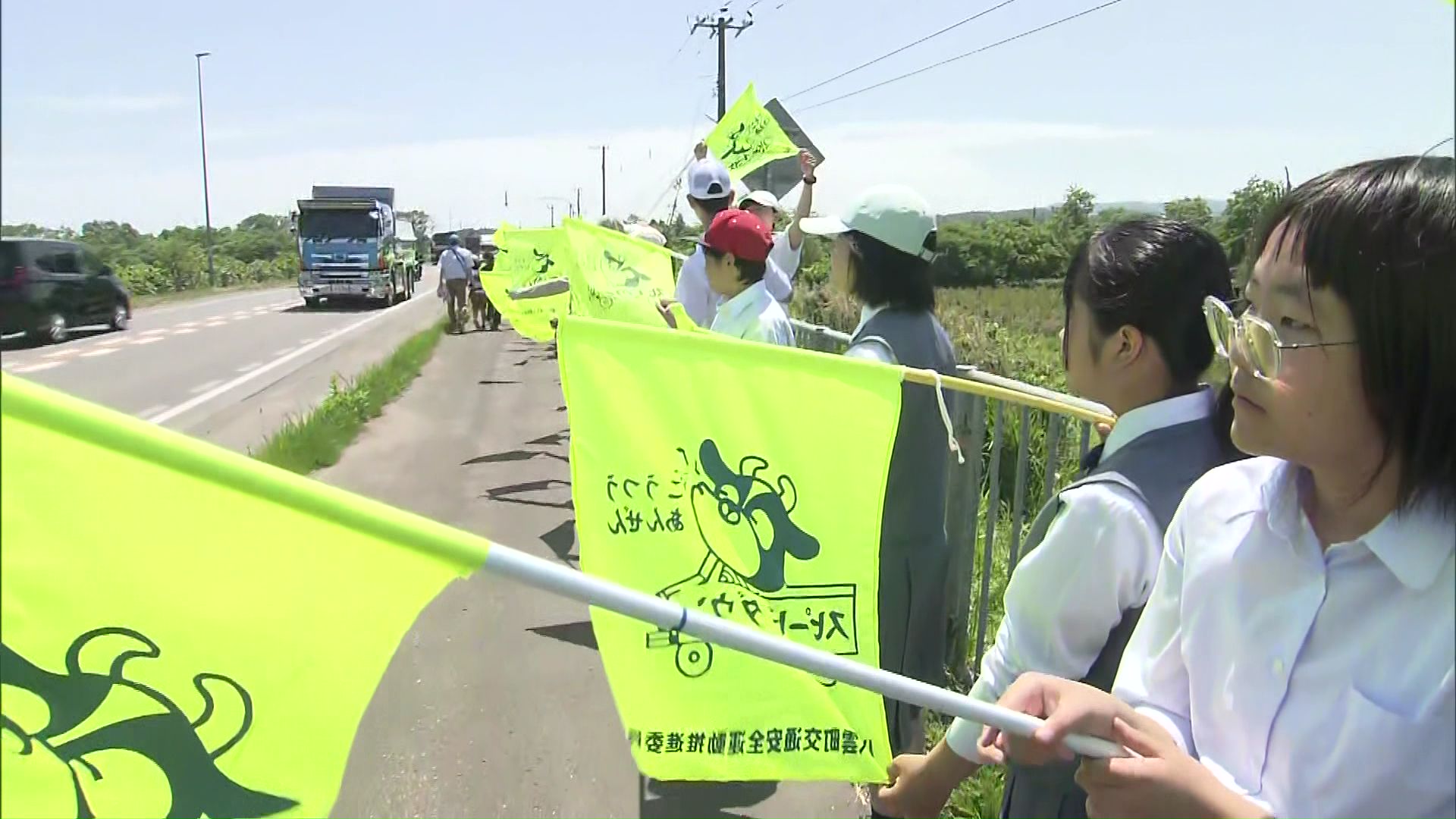 子どもたちが黄色い旗を振り安全運転を呼び掛け