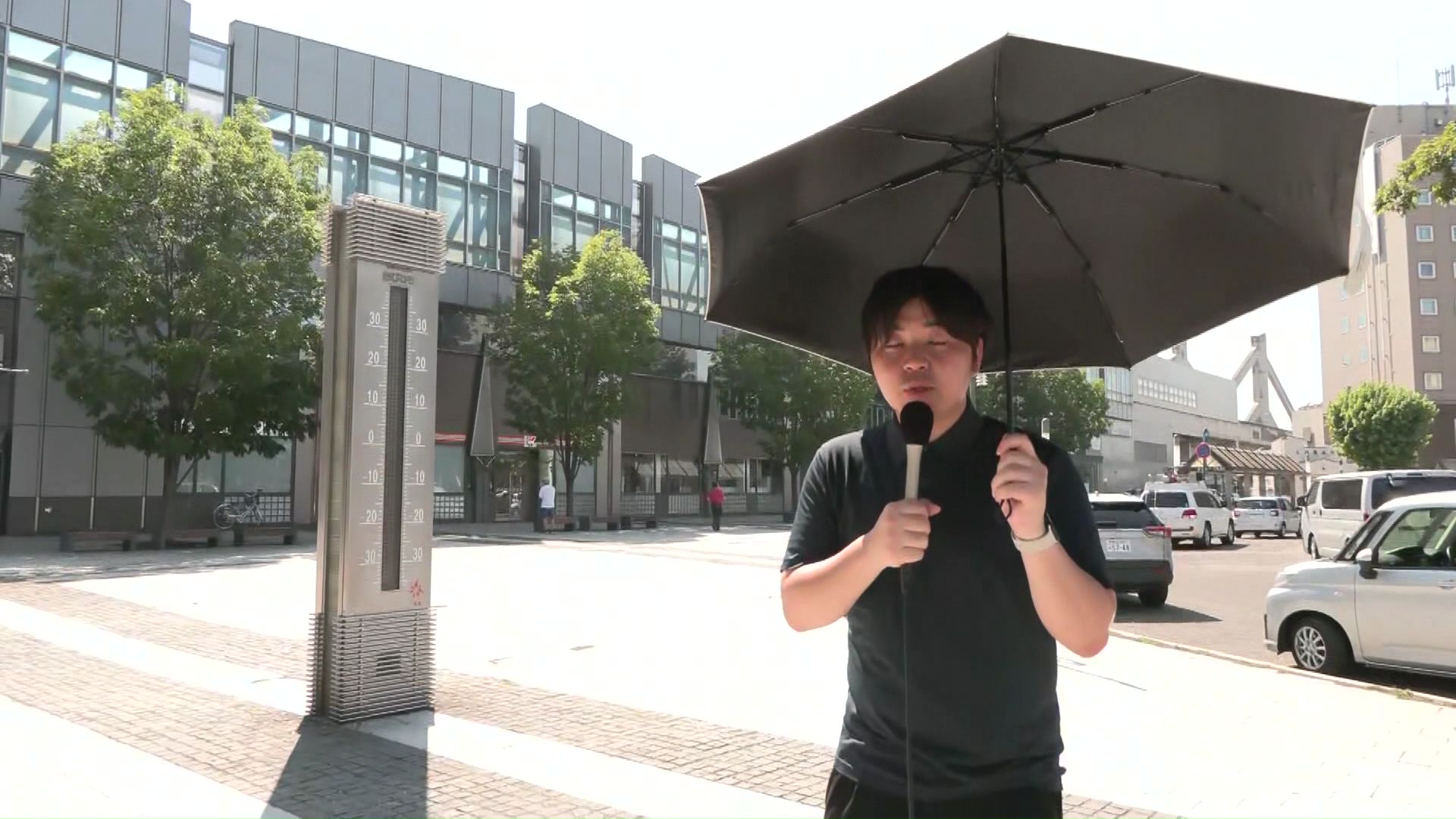 沼田記者も日傘をさしてリポート