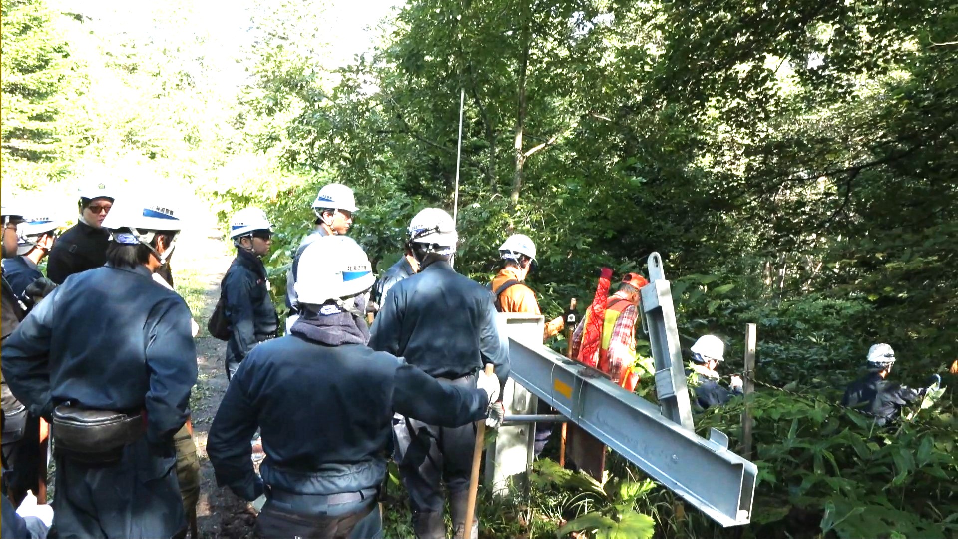 ゲートをくぐり山に入る捜索隊