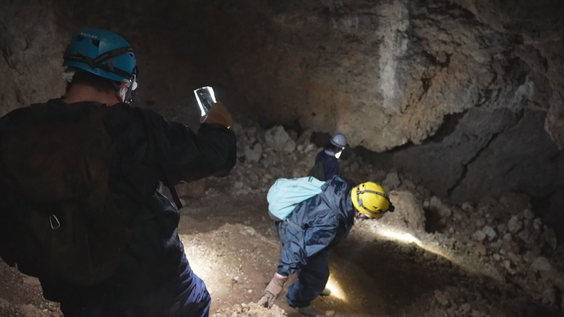 ガマで遺骨を探す宮田さんら