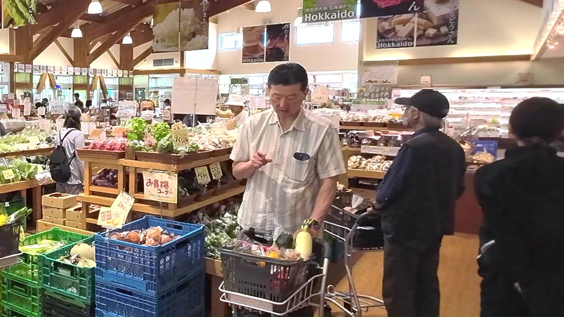 カゴいっぱいの食材をチェックする男性