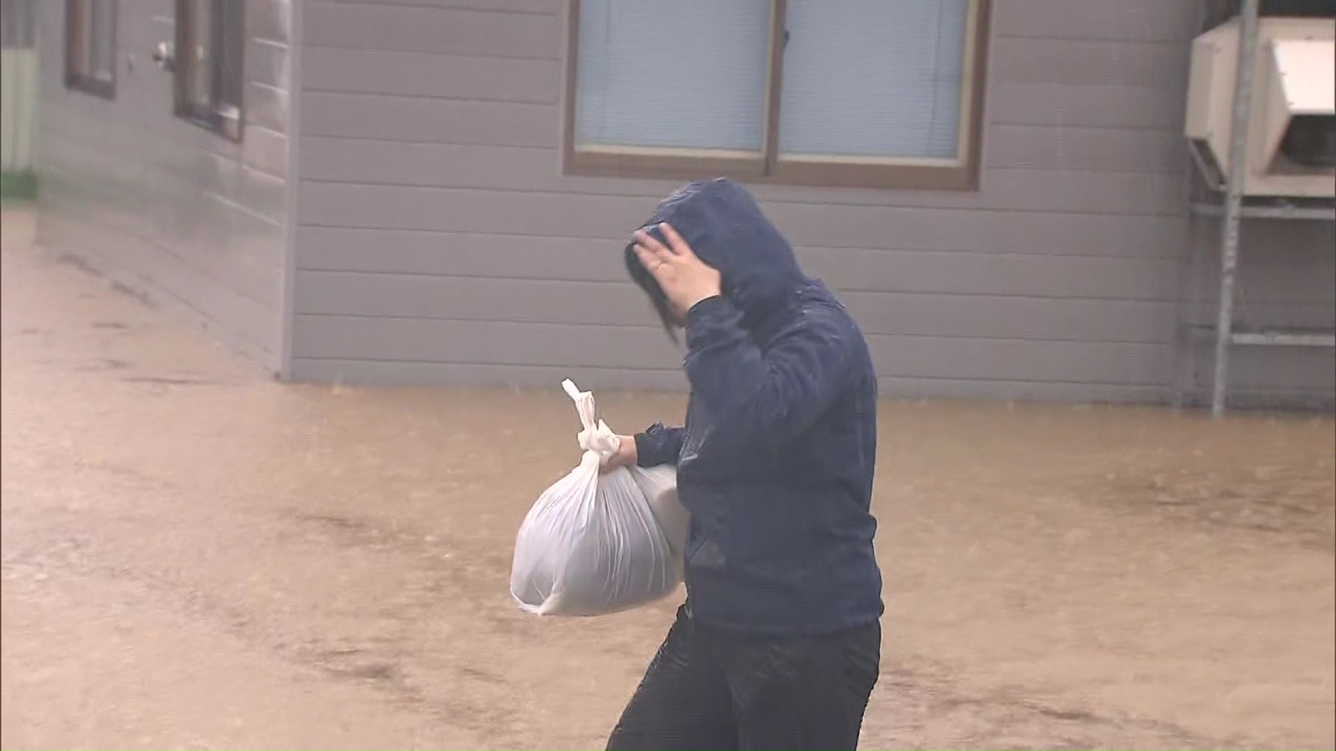 水に浸かった道路を歩く人