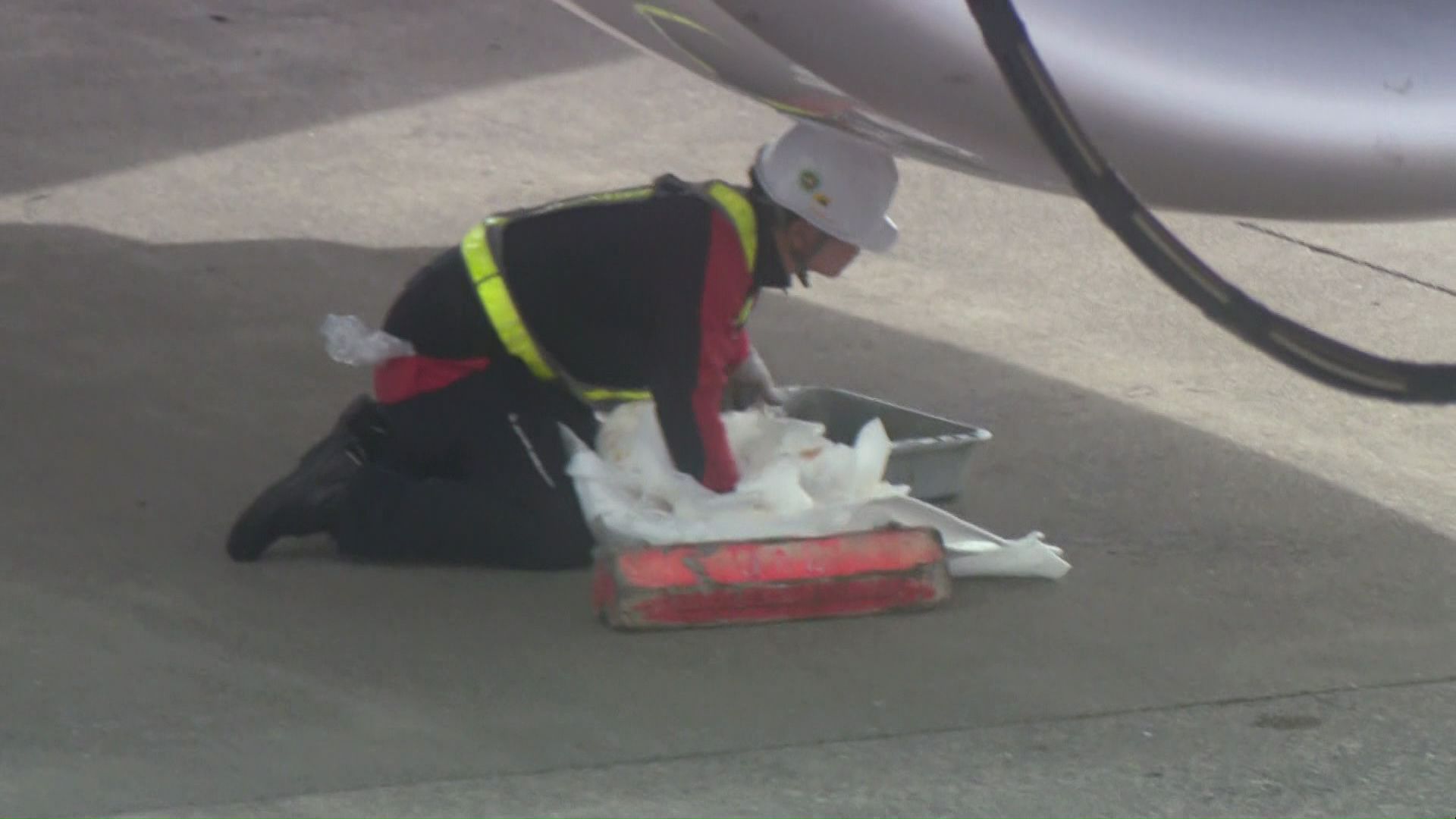 エンジンオイルをふき取っているとみられる作業員