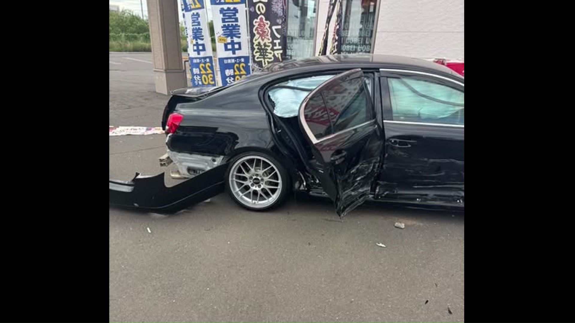 車や店舗にバックで衝突した黒い乗用車