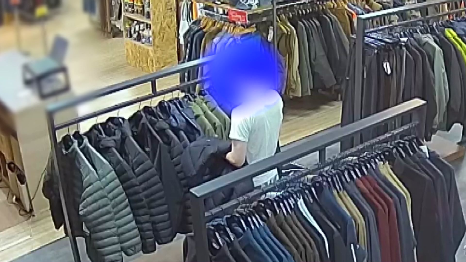 商品を自分のダウンで隠す瞬間