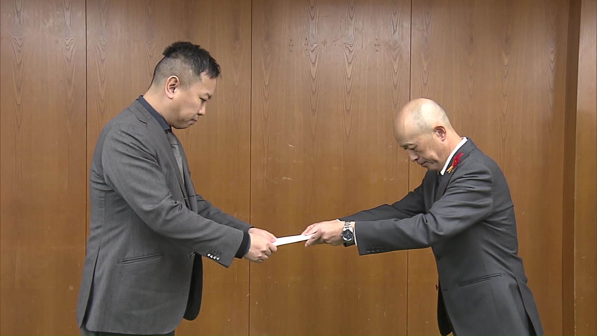 加納副知事（右）から業指導の文書を受け取る「日本エコロジー」の松井社長（11月13日）