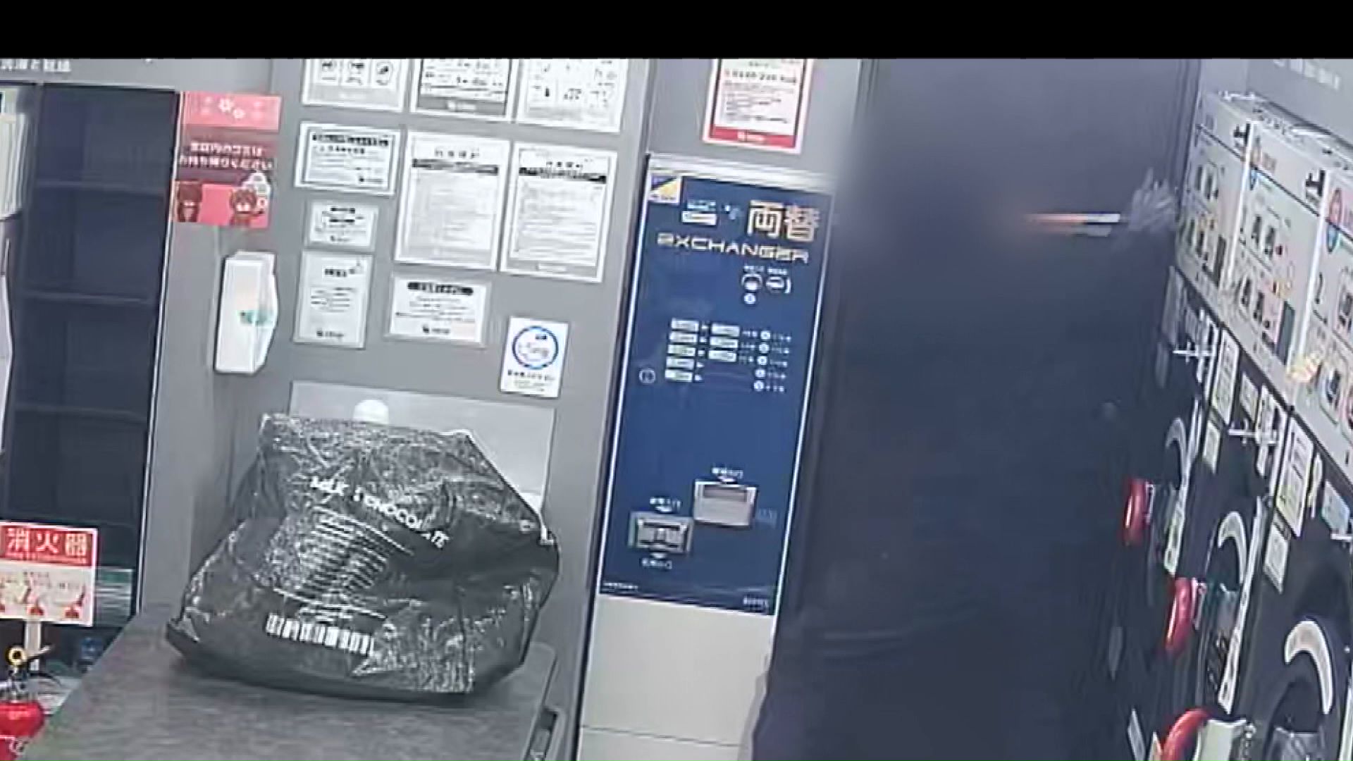 両替機を工具で必死にこじ開けようとする(防犯カメラの映像)