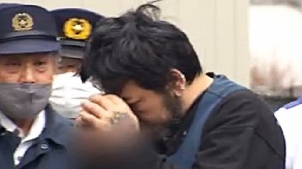 顔を隠す中村容疑者 鼻と耳にピアス、手の甲にはタトゥーが