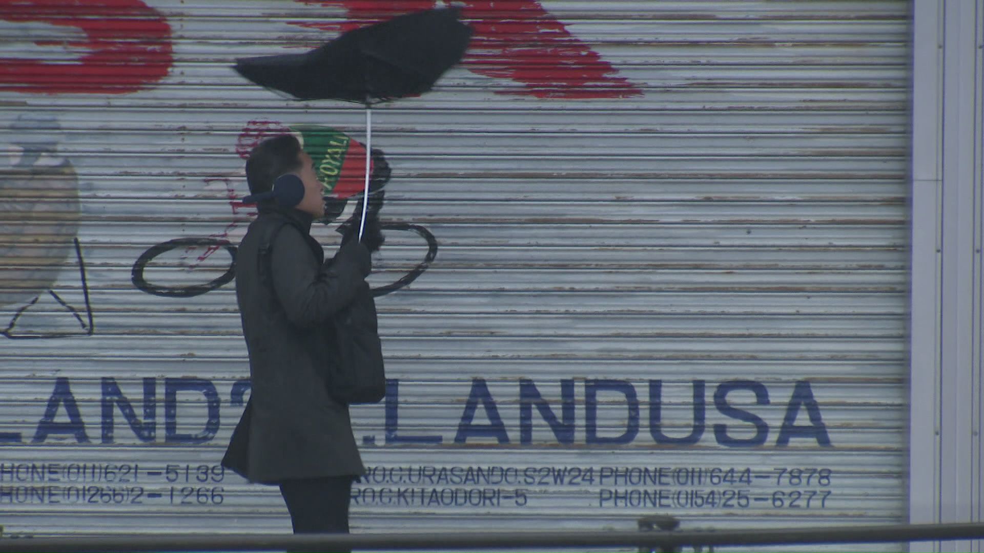 突風に傘が裏返る光景も