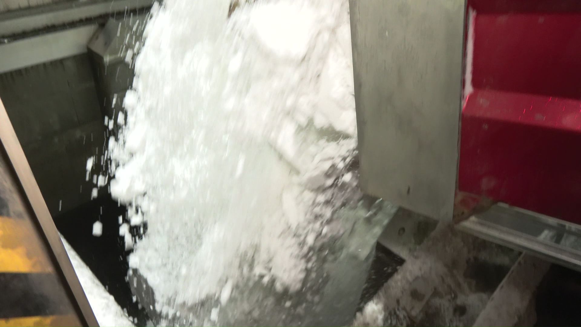 地上ではダンプカーがプールへと雪を降ろす