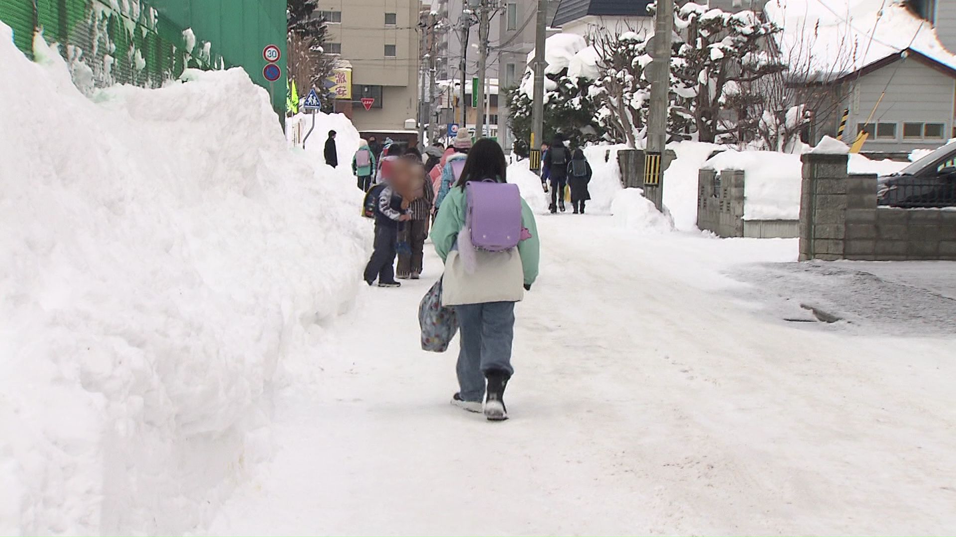 歩道が雪で埋まり、車道を歩く様子