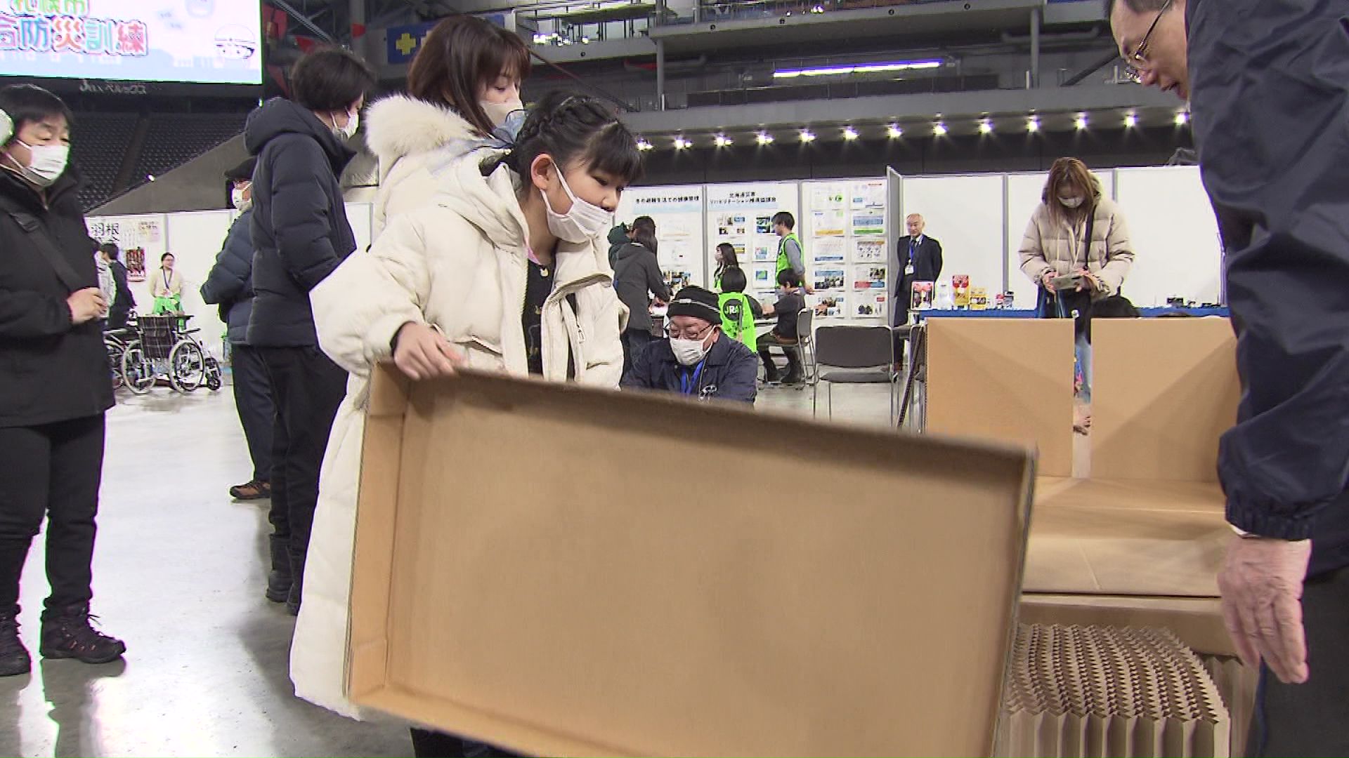 ダンボールベッドの組み立て体験をする子供たち