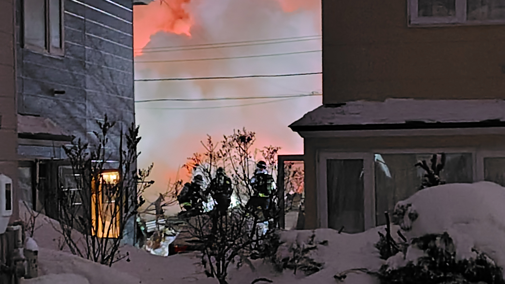 倒壊して炎上する住宅の消火活動を行う消防隊（札幌 手稲区）