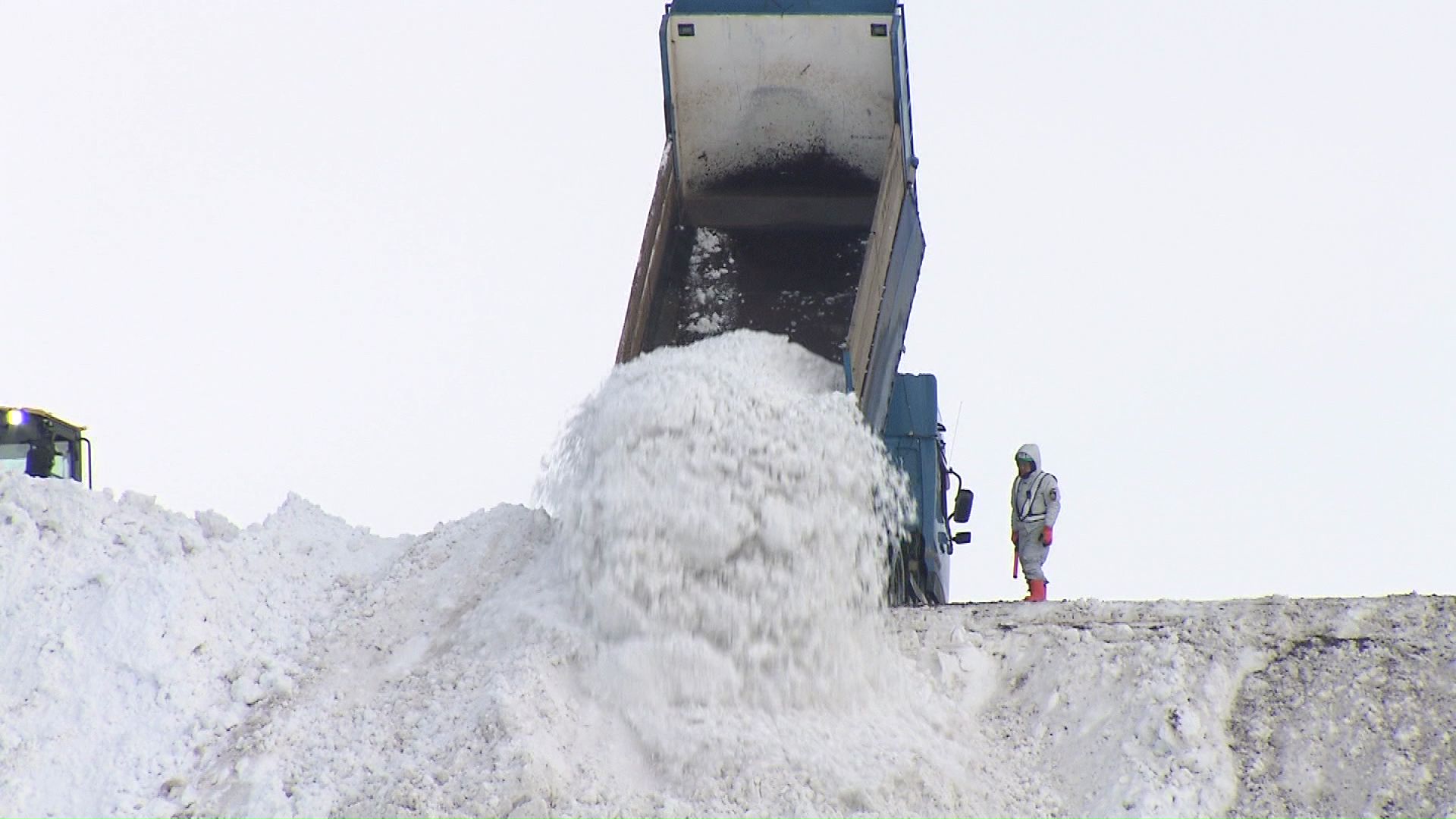 雪を大量に載せたトラックが続々と堆積場に到着