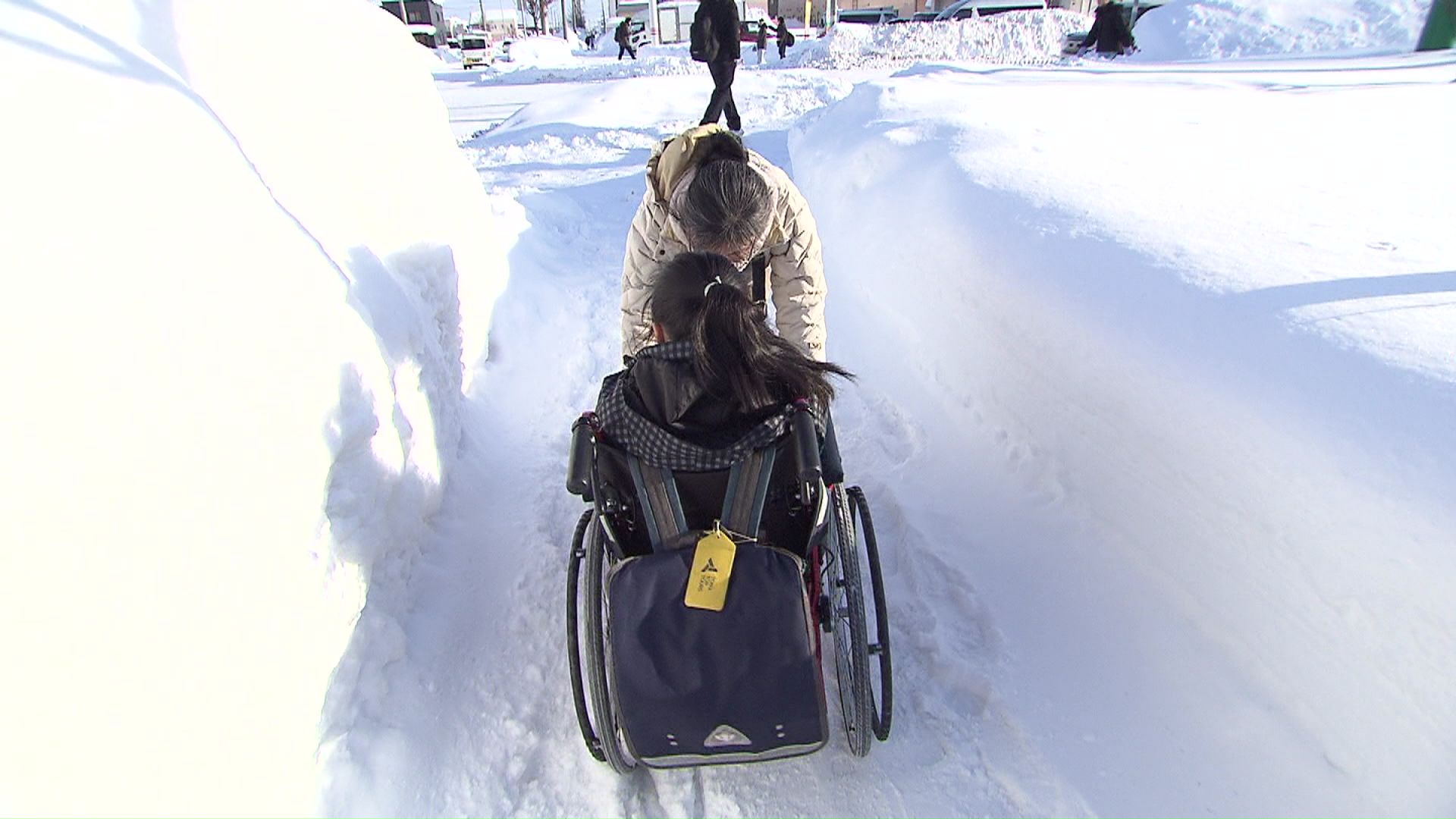 雪の中で車いす登校