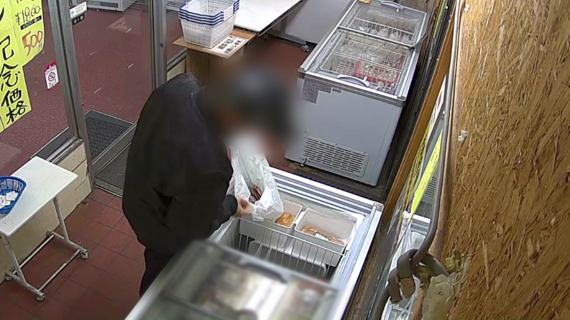 商品を物色し袋に詰める男