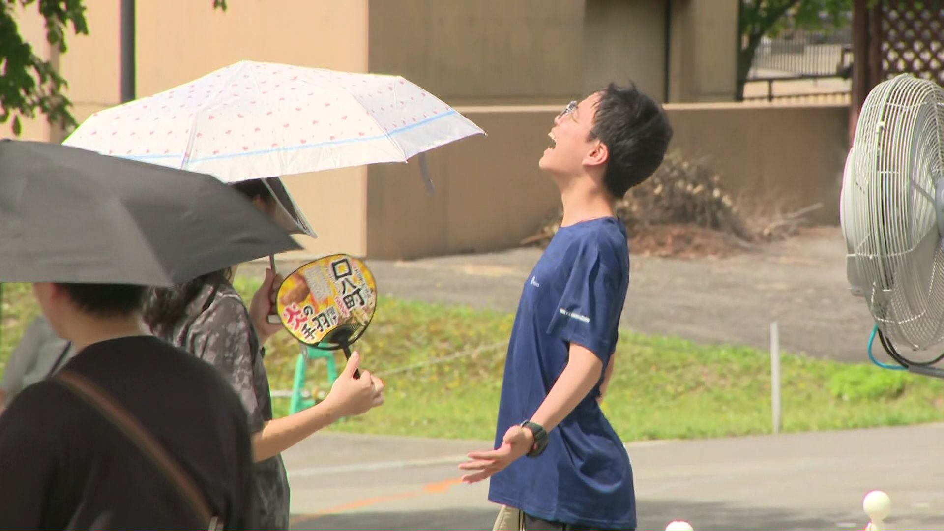 園内の扇風機で涼む観光客