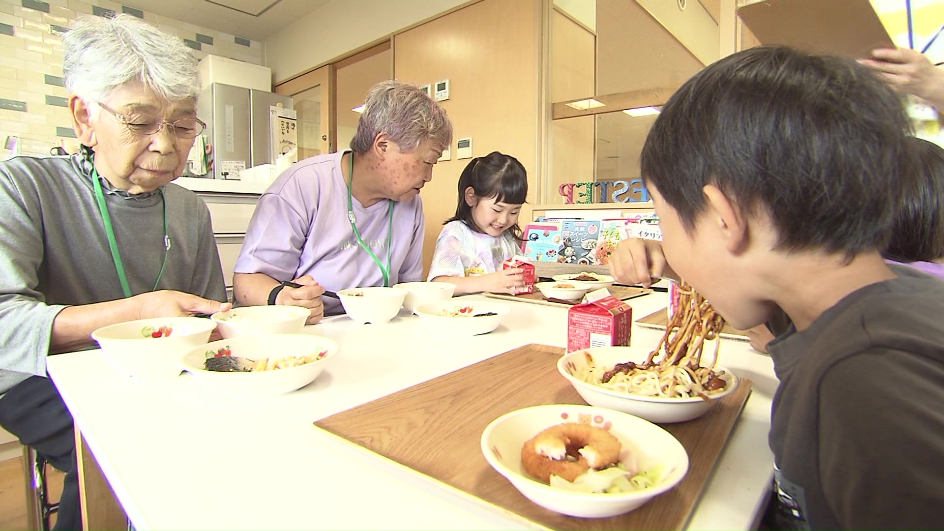 子どもたちと一緒に給食を食べる高齢者