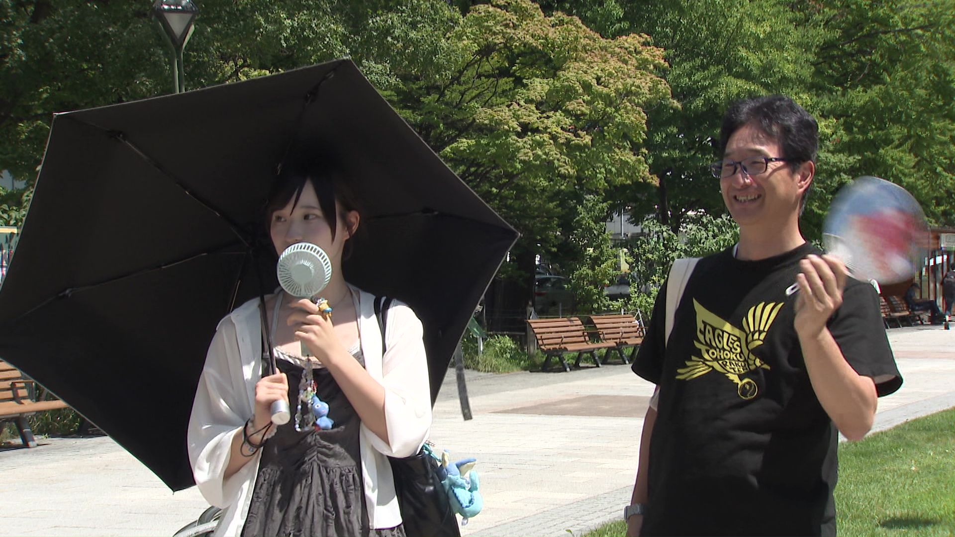 日傘やハンディファンで暑さを回避する人も