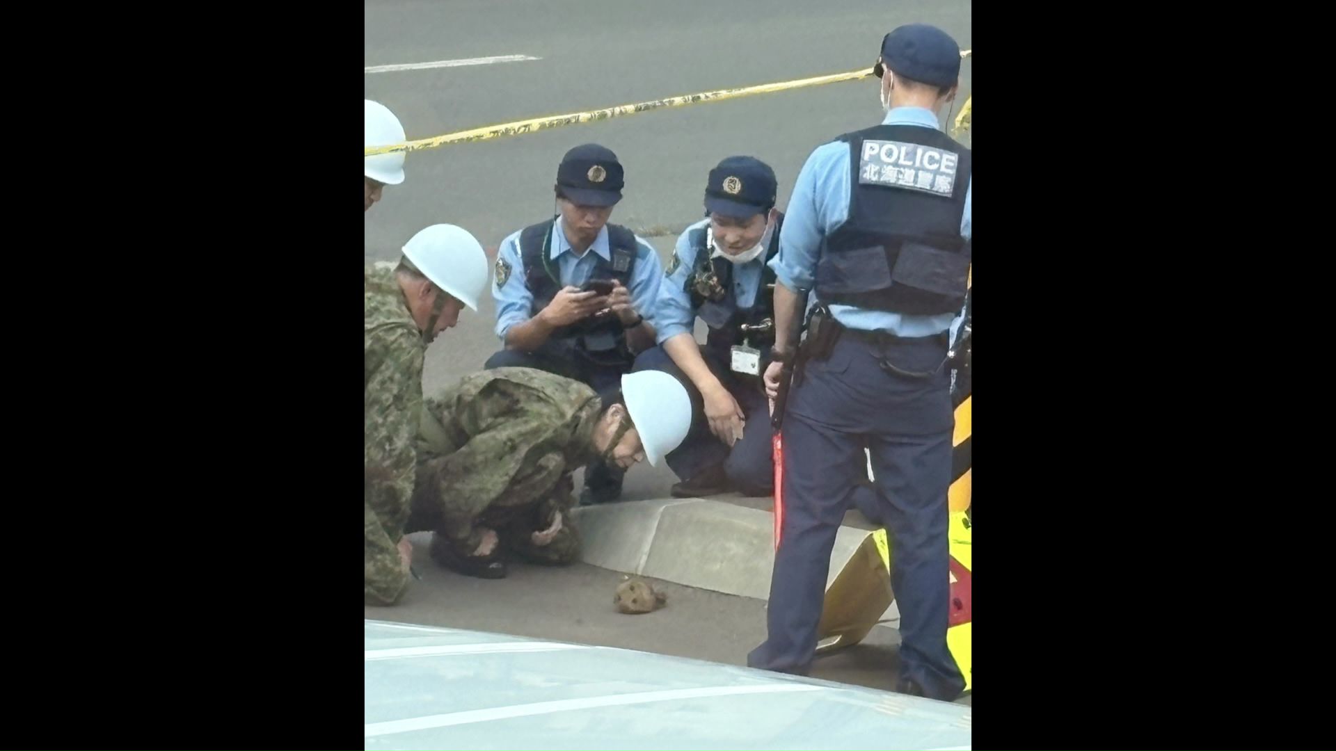 警察官や自衛隊員の視線の先に、不審なポーチ（提供：視聴者）