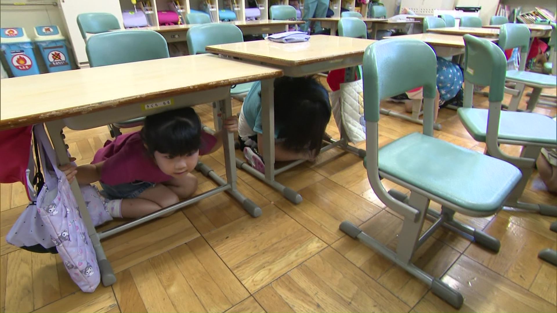 机の下に身を隠す増毛小学校の子どもたち